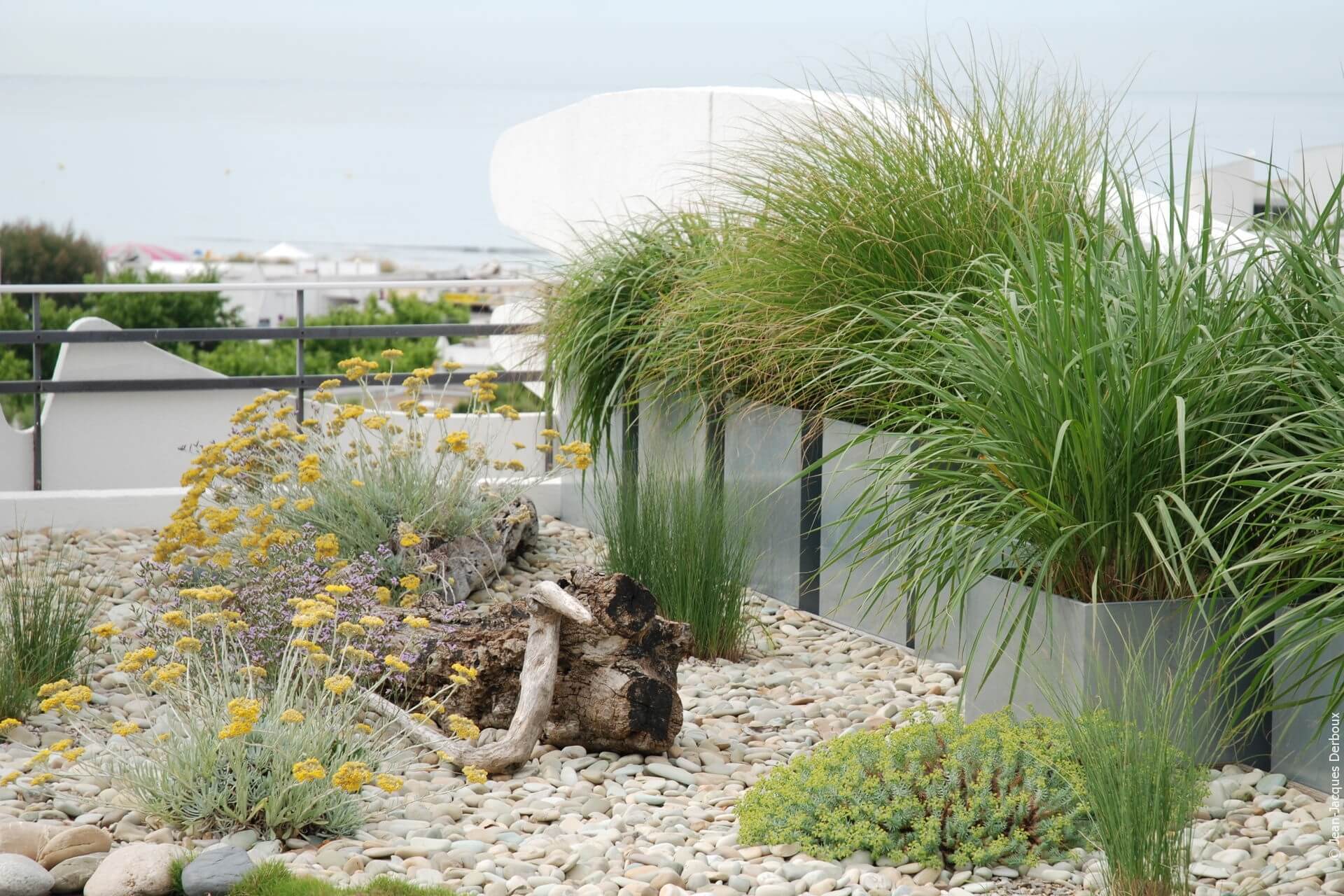 Une terrasse esprit Camargue, jardin sec, galets, graminées, jardinières en métal, bois flottés.