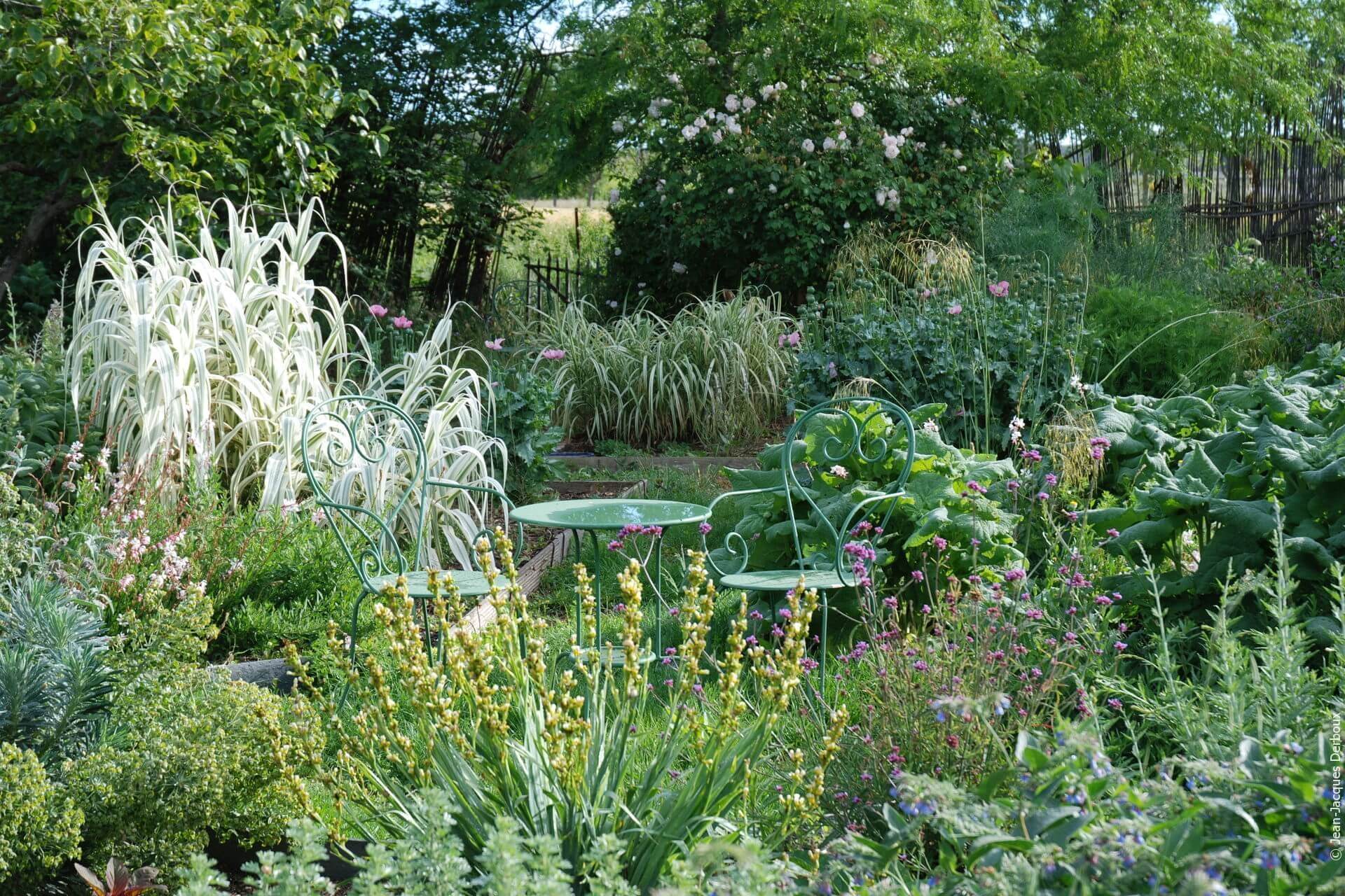 Jardin romantique, bucolique, champêtre, mobilier de jardin en métal, fleurs au printemps.